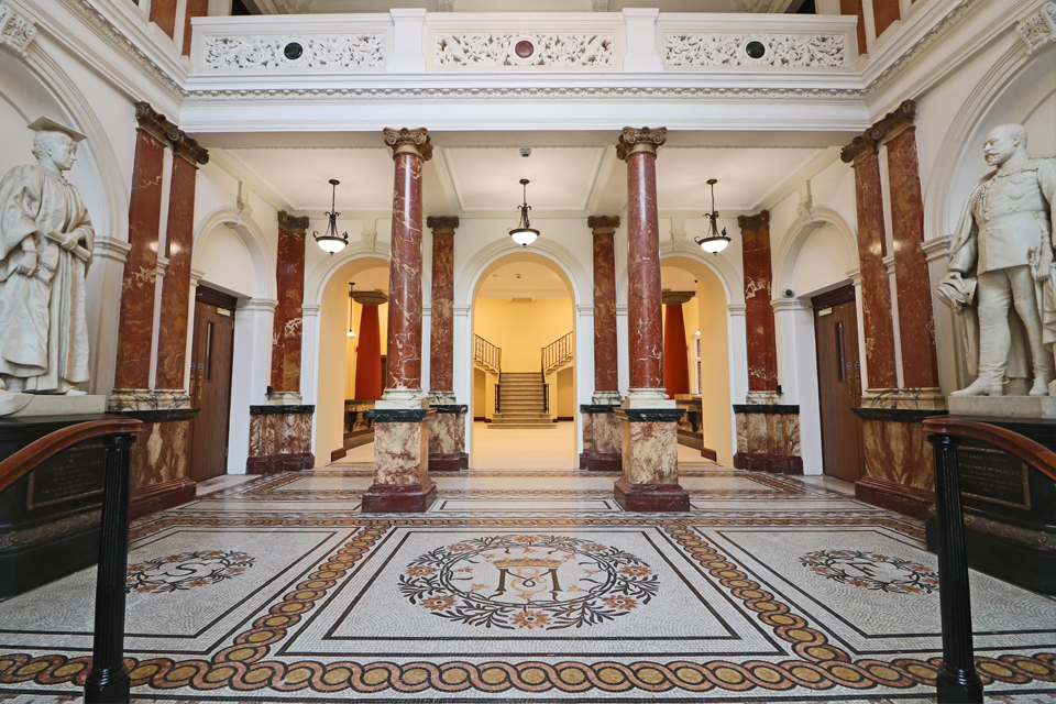 A marble entrance with columns at the entrance to an old historical building.